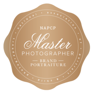 Gold circular seal badge saying 'Master Photographer' with 'NAPCP' and 'Brand Portraiture' surround text about professional portrait photographers.