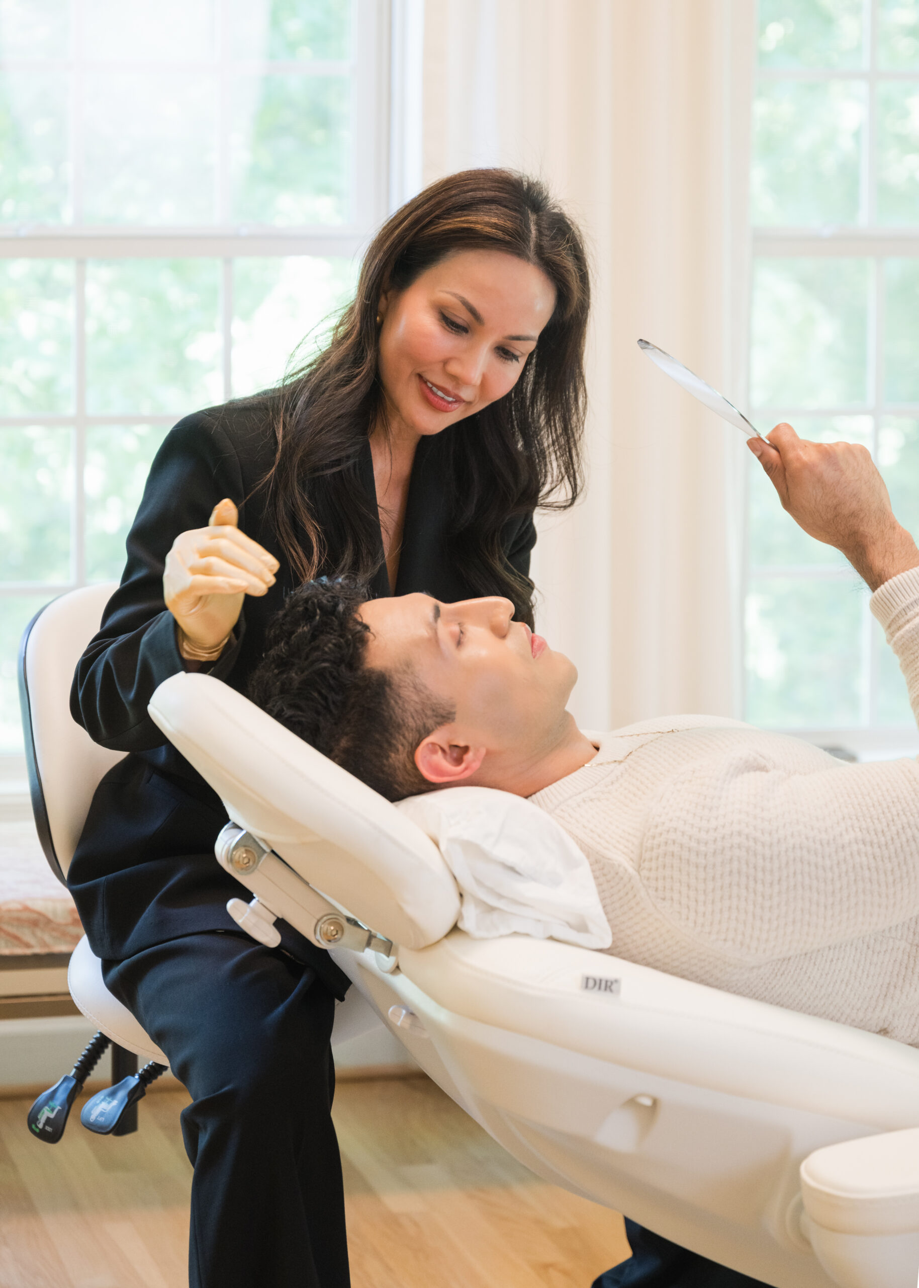 Aesthetic provider performing a cosmetic facial treatment during a branding photography session.